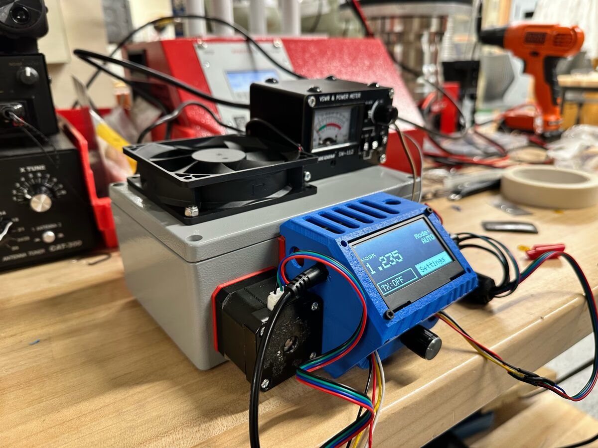 Automated impedance matcher prototype in the Hacker Fab showing VSWR 1.235 on the OLED display